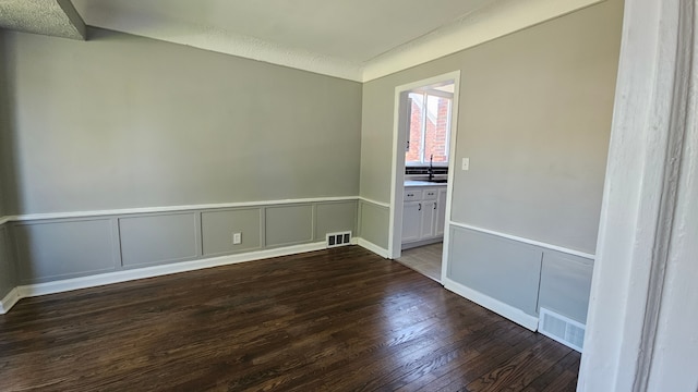 15465 Murray Hl, Detroit, MI 48227 - spare room featuring wood-type flooring, wainscoting, a sink, and a decorative wall