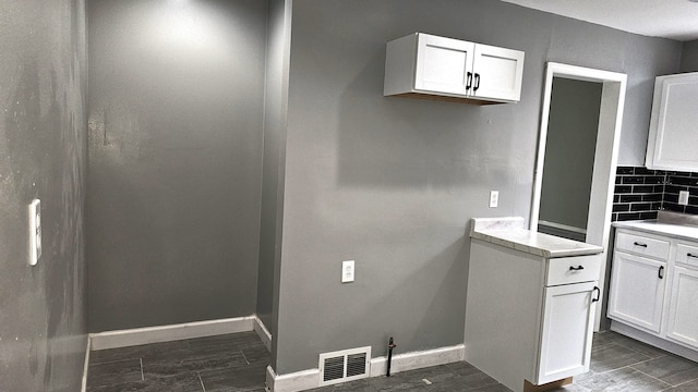 15465 Murray Hl, Detroit, MI 48227 - kitchen featuring white cabinets, light countertops, tasteful backsplash, and baseboards