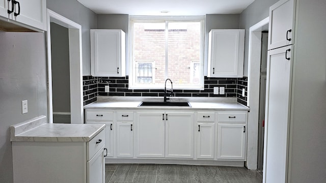 15465 Murray Hl, Detroit, MI 48227 - kitchen featuring a sink, white cabinetry, light countertops, and backsplash