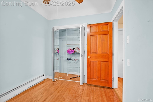 2393 Burger St, Hamtramck, MI 48212 - unfurnished bedroom featuring a baseboard radiator, light wood-style floors, and a closet