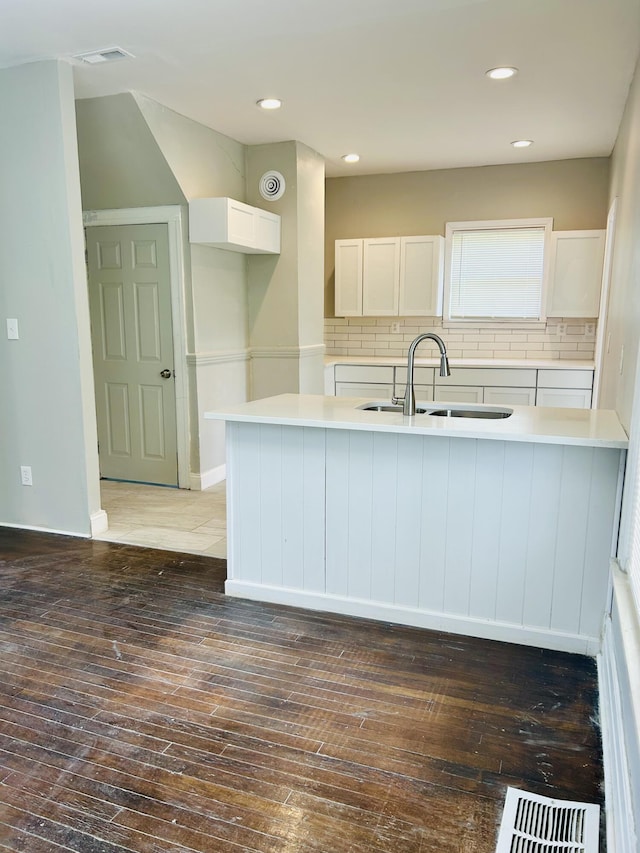 2927 Seyburn St, Detroit, MI 48214 - kitchen with hardwood / wood-style flooring, white cabinetry, a sink, tasteful backsplash, and light countertops