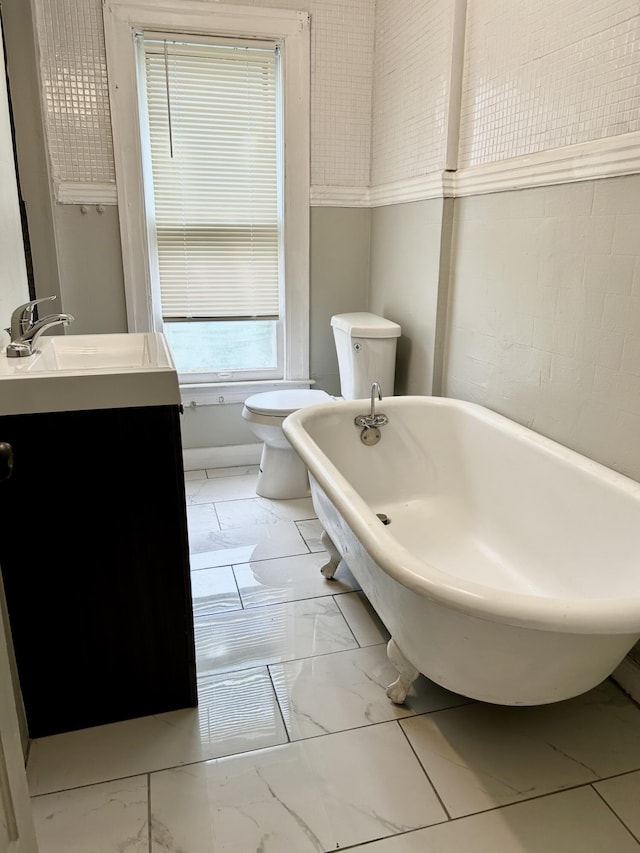 2927 Seyburn St, Detroit, MI 48214 - full bathroom with marble look tiles, toilet, vanity, and a freestanding tub