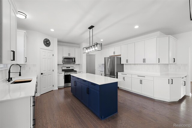 24603 Beach Dr, Macomb, MI 48042 - kitchen featuring appliances with stainless steel finishes, a sink, blue cabinetry, a center island, and tasteful backsplash