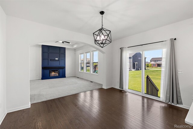 24603 Beach Dr, Macomb, MI 48042 - unfurnished living room with hardwood / wood-style floors, arched walkways, baseboards, a ceiling fan, and a fireplace
