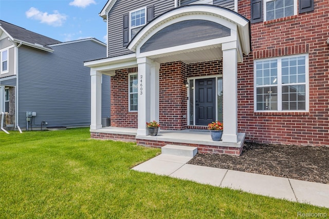 24603 Beach Dr, Macomb, MI 48042 - doorway to property featuring brick siding and a lawn