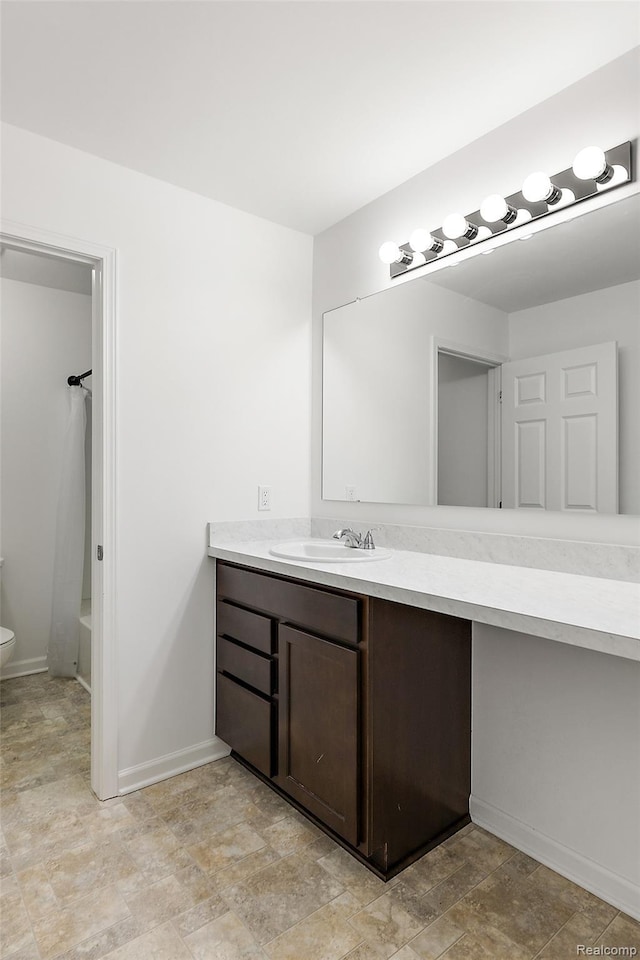 24603 Beach Dr, Macomb, MI 48042 - full bathroom with vanity, toilet, stone finish flooring,  shower combination, and baseboards