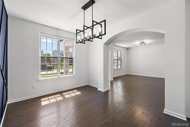 24603 Beach Dr, Macomb, MI 48042 - unfurnished room featuring arched walkways, dark wood-style floors, a chandelier, and baseboards