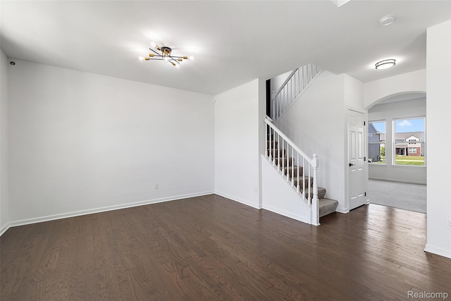 24603 Beach Dr, Macomb, MI 48042 - unfurnished room featuring arched walkways, stairs, wood finished floors, a smoke detector, and baseboards