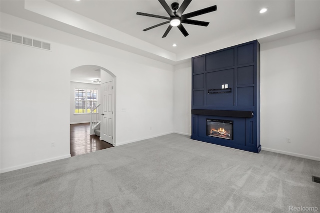 24603 Beach Dr, Macomb, MI 48042 - unfurnished living room featuring a raised ceiling, carpet flooring, a ceiling fan, arched walkways, and recessed lighting