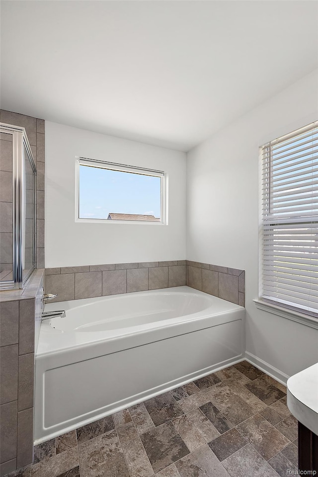 24603 Beach Dr, Macomb, MI 48042 - full bathroom featuring a bath, stone finish floors, and baseboards