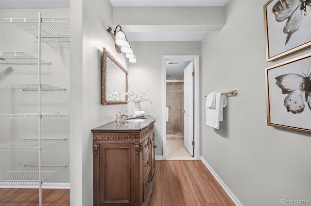 3553 Port Cove Dr Unit 39, Waterford, MI 48328 - full bathroom featuring vanity, wood finished floors, baseboards, and a tile shower