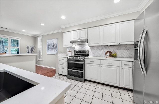 3553 Port Cove Dr Unit 39, Waterford, MI 48328 - kitchen with stainless steel appliances, under cabinet range hood, light countertops, white cabinetry, and tasteful backsplash