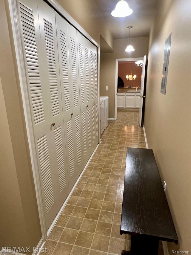 46117 Rhodes Dr Unit 298, Macomb, MI 48044 - hallway with separate washer and dryer, electric panel, a chandelier, baseboards, and a sink