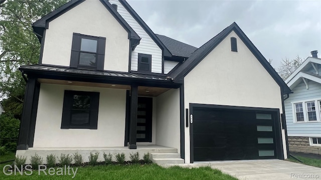 206 E Windemere Ave, Royal Oak, MI 48073 - view of front of house featuring a standing seam roof, stucco siding, a garage, and concrete driveway