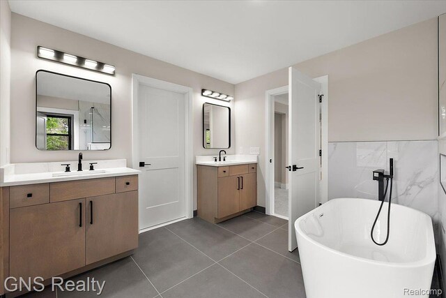 206 E Windemere Ave, Royal Oak, MI 48073 - bathroom featuring a soaking tub, two vanities, and tile patterned flooring