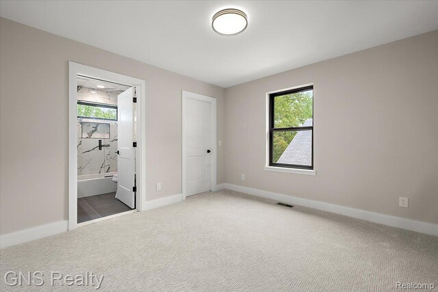 206 E Windemere Ave, Royal Oak, MI 48073 - unfurnished bedroom with multiple windows, carpet floors, and ensuite bath