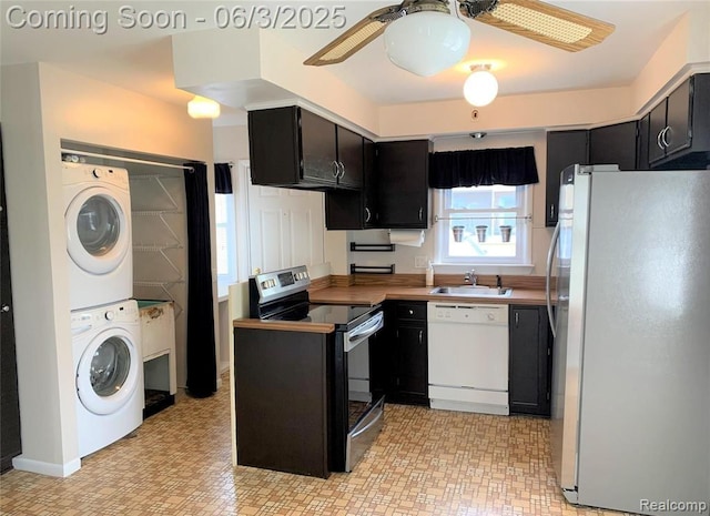 28132 Brentwood St, Southfield, MI 48076 - kitchen featuring appliances with stainless steel finishes, stacked washer / dryer, a sink, dark cabinetry, and a ceiling fan