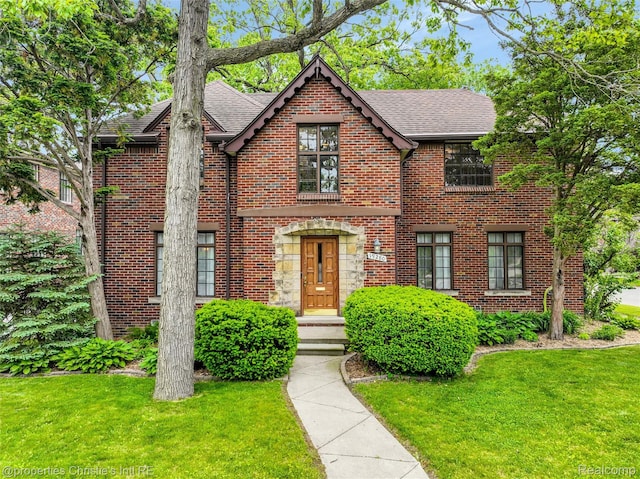 19280 Warrington Dr, Detroit, MI 48221 - tudor home with brick siding, a front lawn, and a shingled roof