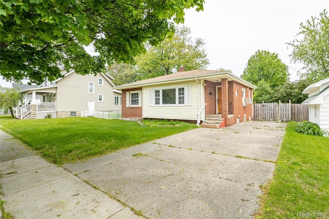 2028 9th St, Port Huron, MI 48060 - view of front of house with brick siding, a chimney, concrete driveway, and a porch