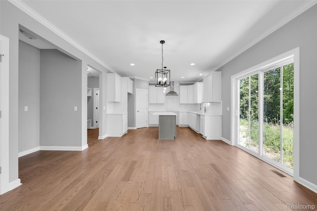 10705 Deer Ridge Trl, Rose, MI 48442 - unfurnished living room featuring a chandelier, ornamental molding, baseboards, a sink, and light wood-style flooring