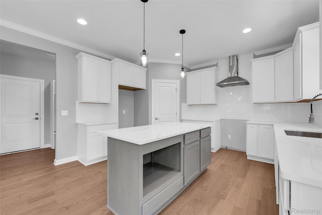 10705 Deer Ridge Trl, Rose, MI 48442 - kitchen featuring wall chimney exhaust hood, a sink, ornamental molding, light wood-style flooring, and decorative light fixtures