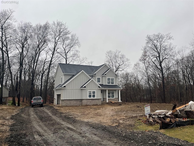 10705 Deer Ridge Trl, Rose, MI 48442 - view of front of house featuring driveway, board and batten siding, a porch, and roof with shingles