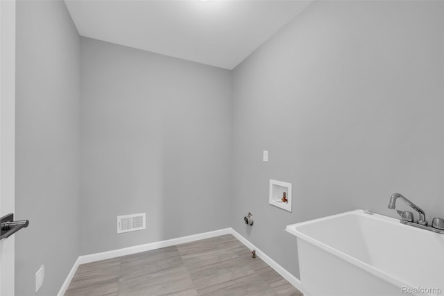 10705 Deer Ridge Trl, Rose, MI 48442 - laundry room featuring washer hookup, baseboards, gas dryer hookup, and wood finished floors