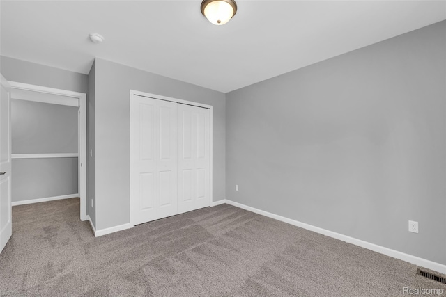 10705 Deer Ridge Trl, Rose, MI 48442 - unfurnished bedroom featuring a closet, carpet floors, and baseboards