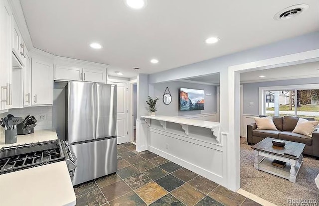 35274 Lake Dr, Brownstown, MI 48173 - kitchen featuring freestanding refrigerator, gas range oven, light countertops, decorative backsplash, and white cabinetry