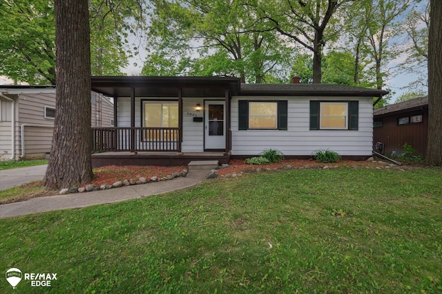 3825 Craig Dr, Flint, MI 48506 - ranch-style house with covered porch and a front yard