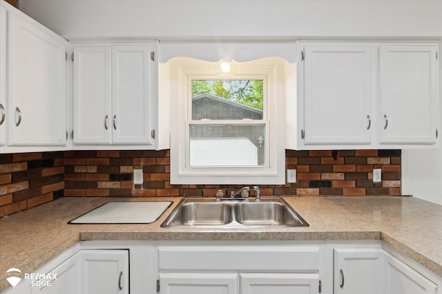 3825 Craig Dr, Flint, MI 48506 - kitchen with a sink, white cabinetry, backsplash, and light countertops