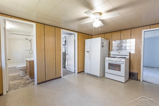 1303 S Warner St, Bay City, MI 48706 - kitchen featuring white appliances, a ceiling fan, wooden walls, brown cabinetry, and baseboards