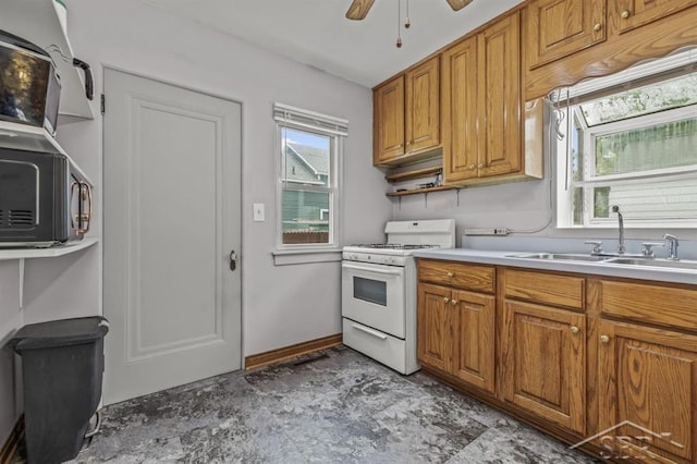 705 W Jenny St, Bay City, MI 48706 - kitchen with white range with gas stovetop, a sink, brown cabinets, and a ceiling fan