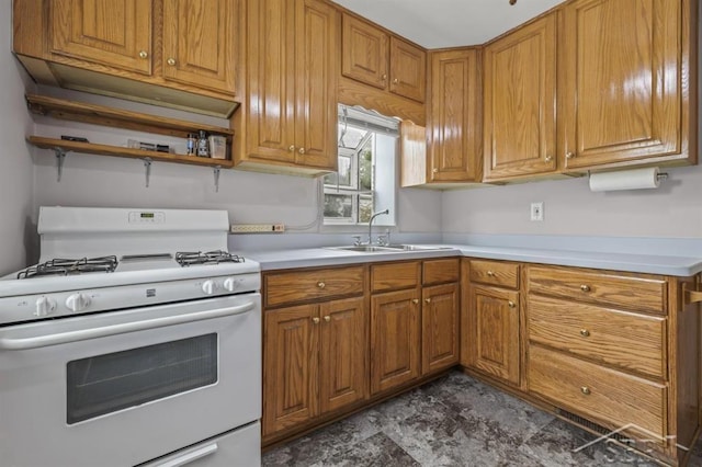 705 W Jenny St, Bay City, MI 48706 - kitchen featuring white gas range, a sink, brown cabinets, light countertops, and open shelves