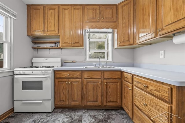 705 W Jenny St, Bay City, MI 48706 - kitchen with gas range gas stove, a sink, and brown cabinets