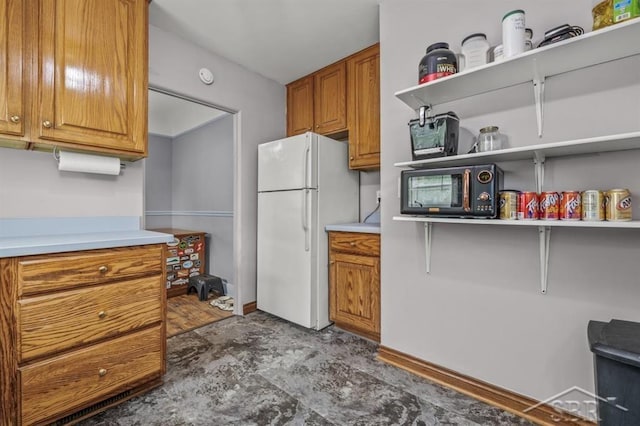 705 W Jenny St, Bay City, MI 48706 - kitchen with freestanding refrigerator, open shelves, black microwave, and brown cabinetry