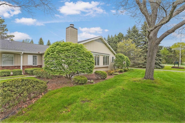 34 Mathison Rd, Traverse City, MI 49686 - view of home's exterior with a chimney, a lawn, and brick siding