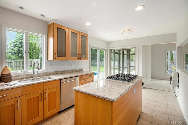 7831 Caberfae Trl, Clarkston, MI 48348 - kitchen featuring stainless steel appliances, a sink, a kitchen island, light stone countertops, and light tile patterned floors