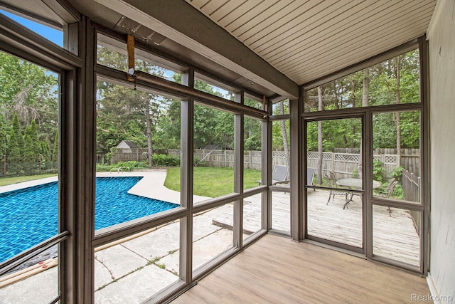 7831 Caberfae Trl, Clarkston, MI 48348 - unfurnished sunroom featuring vaulted ceiling and view of wooded area