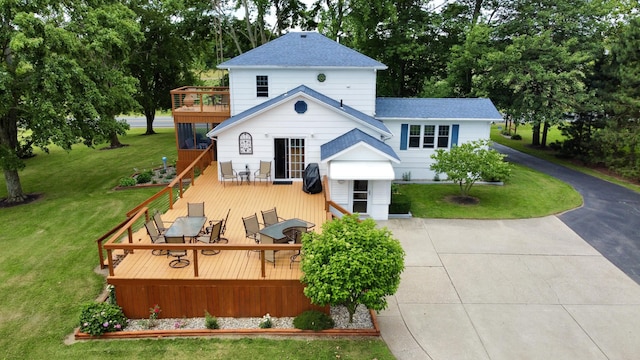 8595 E Napier Ave, Benton Harbor, MI 49022 - back of property featuring roof with shingles, a wooden deck, a yard, view of scattered trees, and driveway