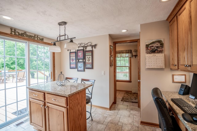 8595 E Napier Ave, Benton Harbor, MI 49022 - kitchen with baseboards, a desk, recessed lighting, a breakfast bar, and light stone finish flooring