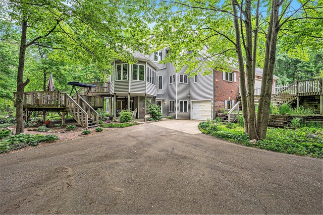 8837 56th Ave, Hudsonville, MI 49426 - view of front facade with stairway, an attached garage, driveway, and a deck
