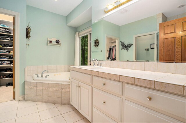 8837 56th Ave, Hudsonville, MI 49426 - bathroom with a garden tub, a spacious closet, vanity, and tile patterned flooring