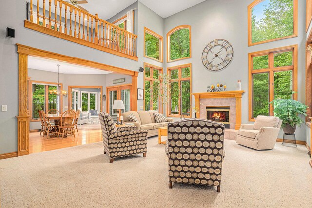 8837 56th Ave, Hudsonville, MI 49426 - carpeted living room with a tiled fireplace, a high ceiling, baseboards, and a chandelier