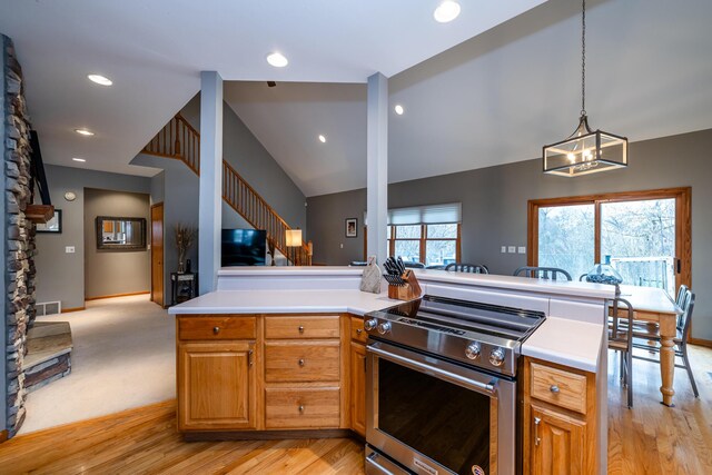 4569 Terra Ln, Saint Joseph, MI 49085 - kitchen with stainless steel range with electric cooktop, open floor plan, light countertops, light wood finished floors, and lofted ceiling