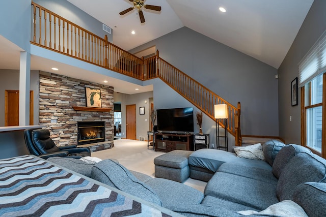 4569 Terra Ln, Saint Joseph, MI 49085 - living room featuring high vaulted ceiling, a ceiling fan, stairway, a stone fireplace, and carpet