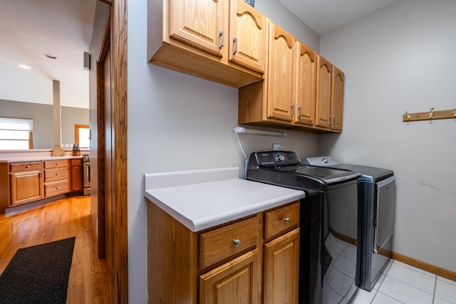 4569 Terra Ln, Saint Joseph, MI 49085 - laundry area with washing machine and clothes dryer, cabinet space, and light tile patterned flooring