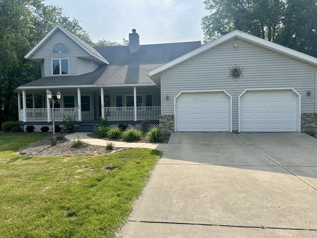 4569 Terra Ln, Saint Joseph, MI 49085 - view of front of home featuring concrete driveway, an attached garage, a chimney, a front yard, and a porch