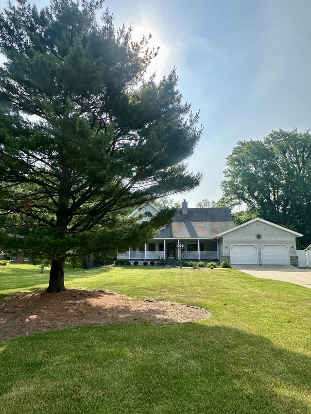 4569 Terra Ln, Saint Joseph, MI 49085 - view of front of home featuring a garage, driveway, a front lawn, covered porch, and a chimney