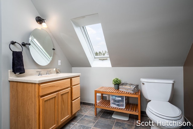 9953 10 Mile Rd NE, Rockford, MI 49341 - bathroom with a skylight, vanity, toilet, vaulted ceiling, and stone finish flooring